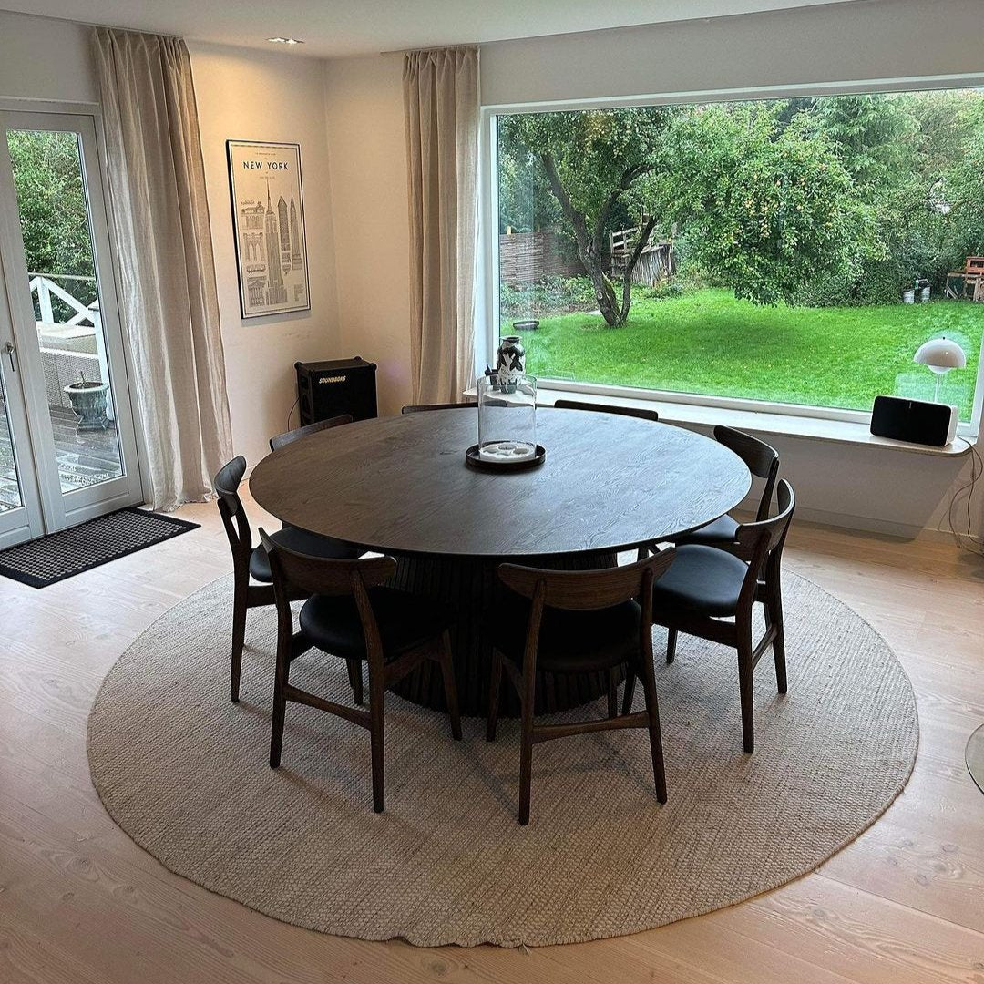 Table à manger ronde extensible en chêne fusain – dotée de son pied à facettes distinctif – est un chef-d'œuvre unique et sur mesure qui allie modernité