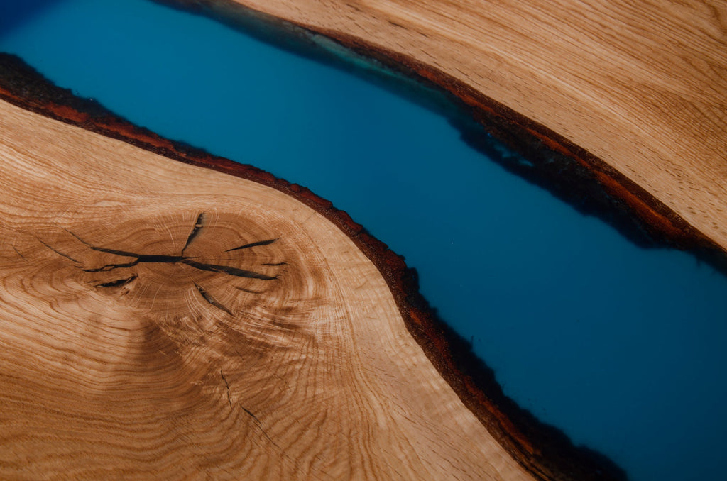 Table en époxy bleue - Succombez au charme de notre table rivière - avec un piètement trapèze - L'alliance de l'orme et de la résine colorée en fait une véritable œuvre d'art