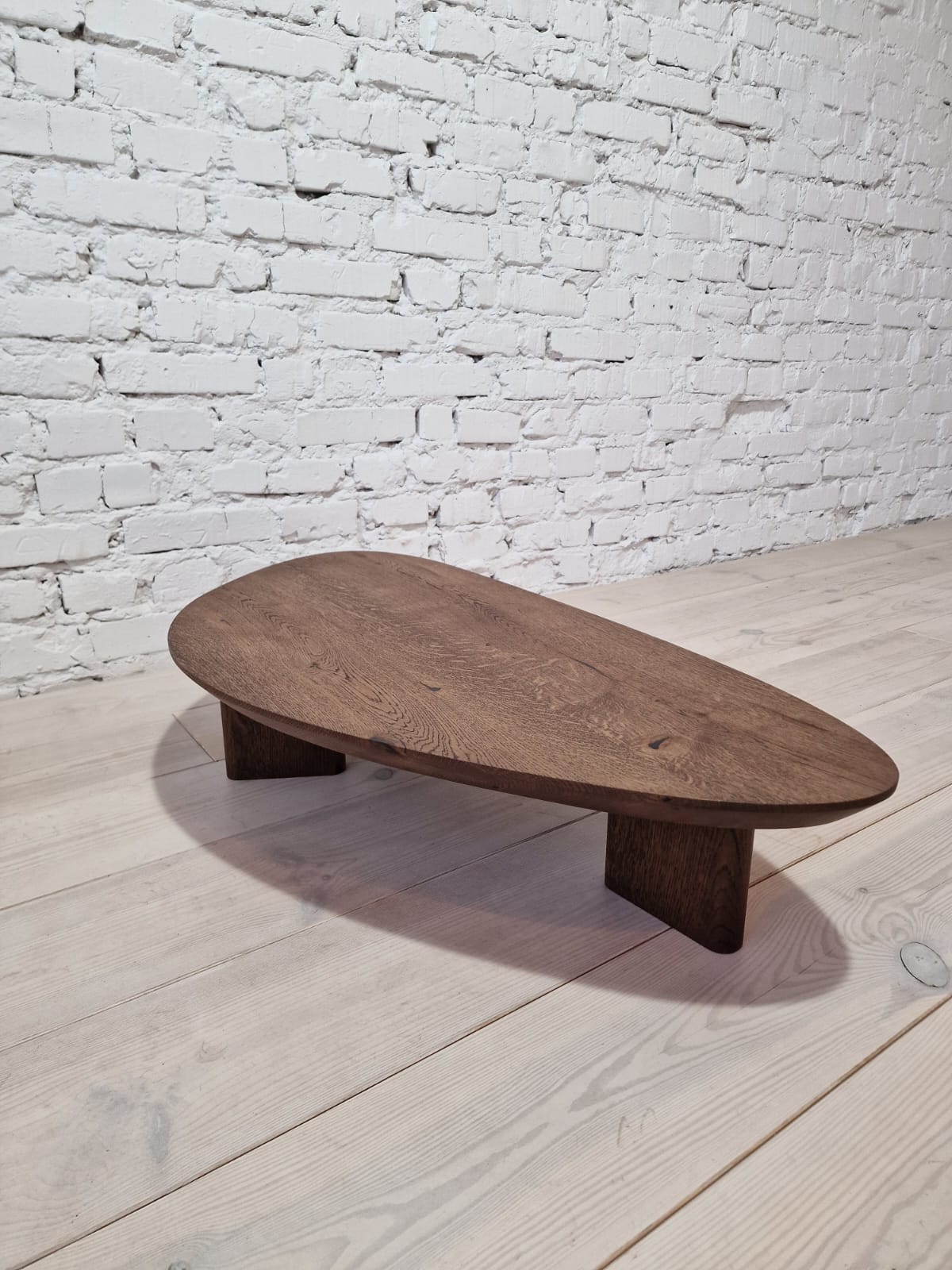 Table basse en chêne – Cette table basse présente une forme magnifiquement organique façonnée à partir de chêne massif, mettant en valeur sa surface naturellement lisse et