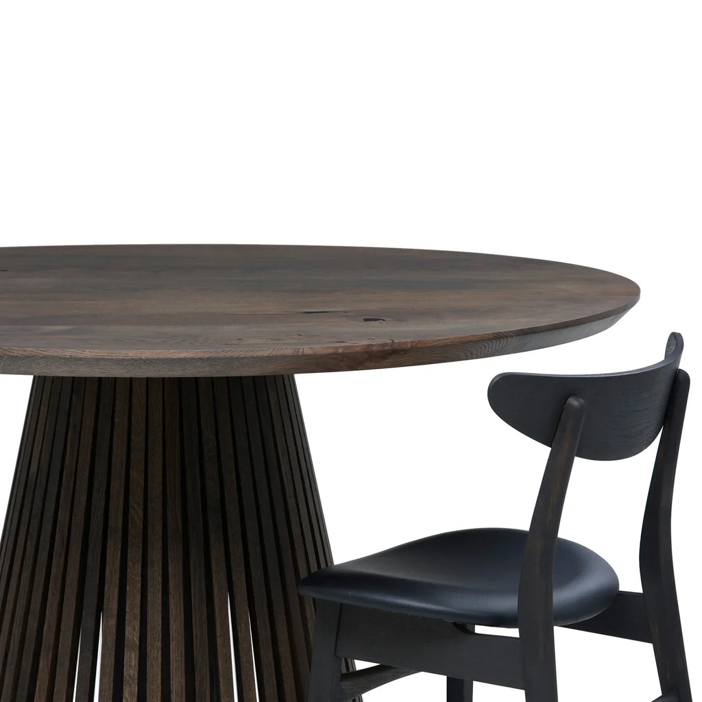 Table à manger ronde extensible en chêne fusain – dotée de son pied à facettes distinctif – est un chef-d'œuvre unique et sur mesure qui allie modernité